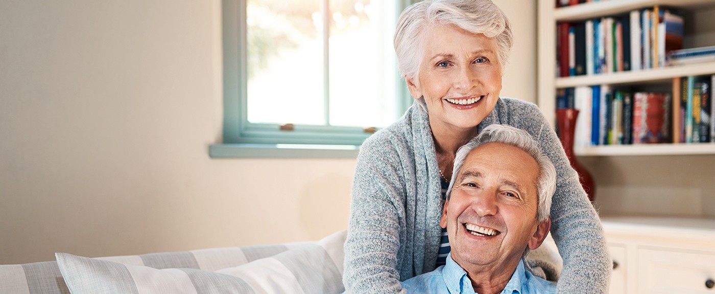 Happy older couple embracing in living room