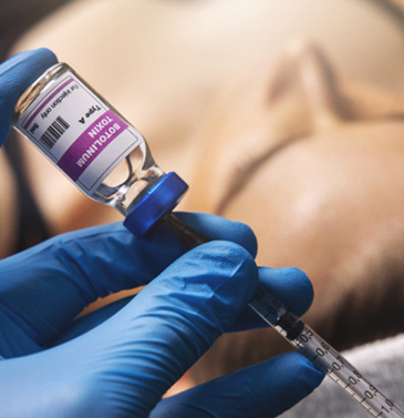 Gloved hands preparing BOTOX injection