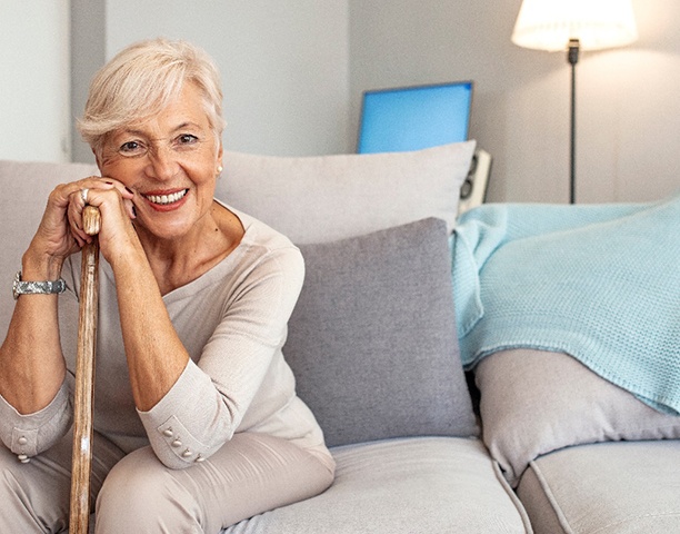 Woman smiling while sitting on couch at home