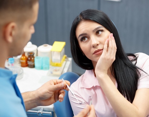 Woman with tooth pain visiting emergency dentist in Orlando