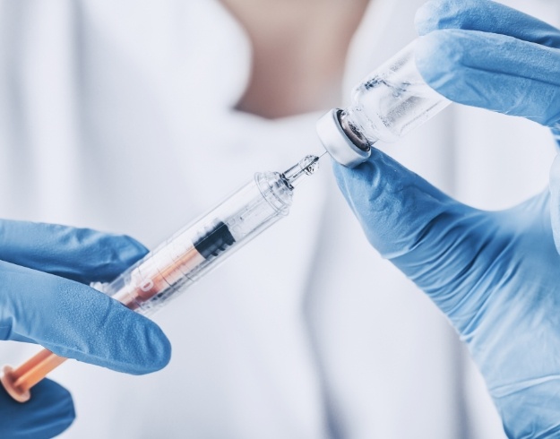 Dentist holding needle and a clear bottle