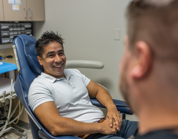 Woman sitting back in dental chair and smiling