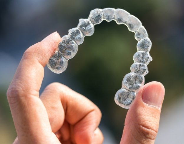 Close up of SureSmile clear aligner in hand