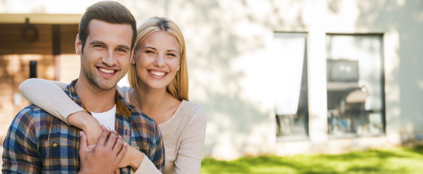 Woman hugging man from behind and smiling