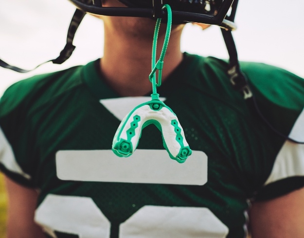 Mouthguard dangling from helmet of football player